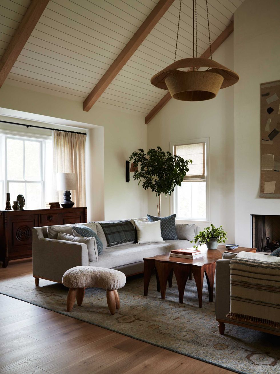 Cozy living room with a vaulted ceiling, modern furniture, and large windows.