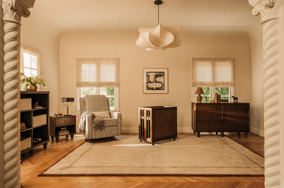 Cozy living room with armchair, wooden furniture, and modern pendant light.