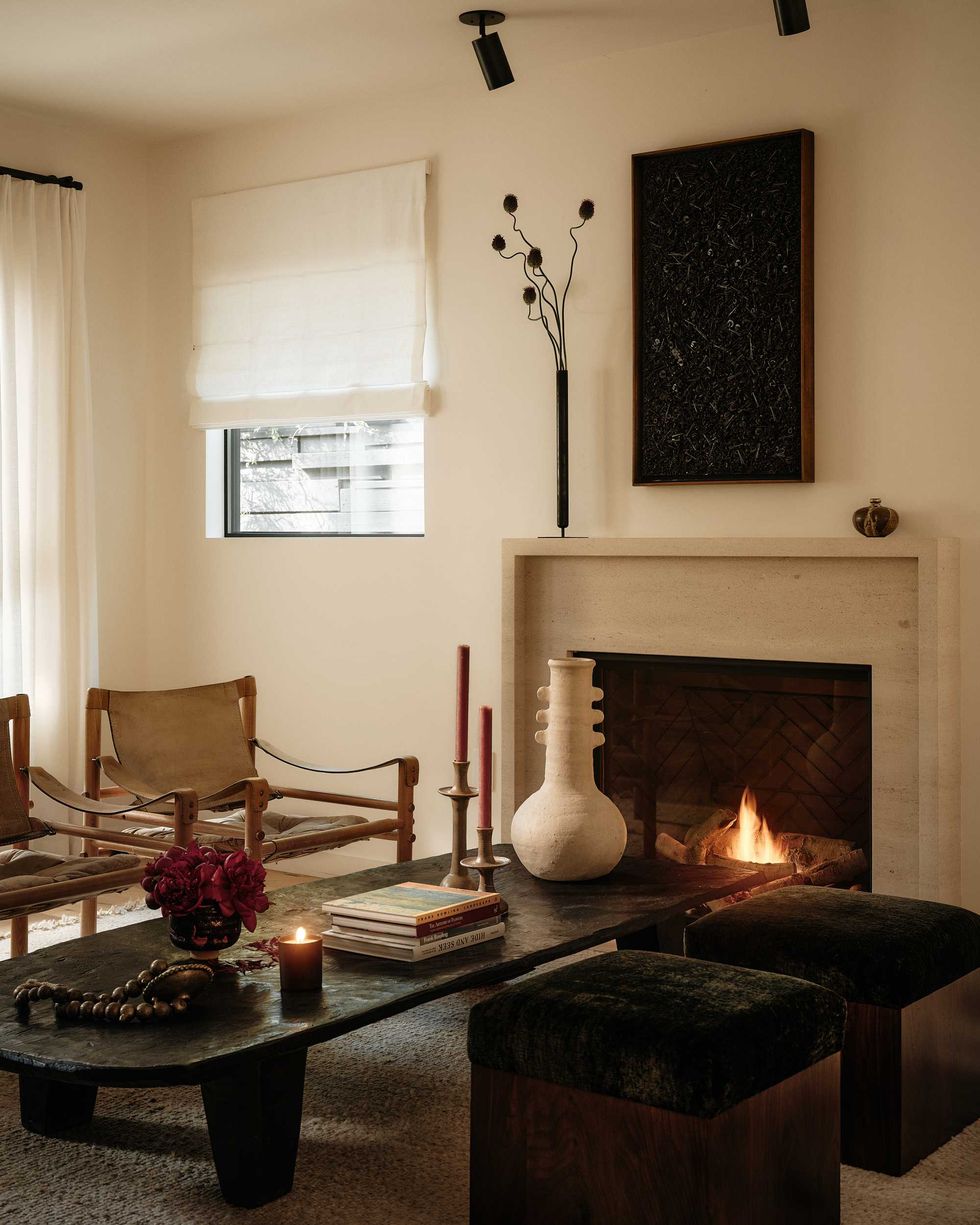 Cozy living room with fireplace, elegant decor, and a dark wood coffee table.