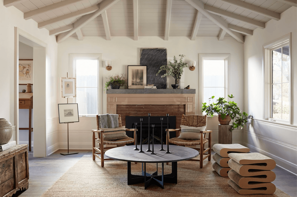 Cozy living room with fireplace, natural wood furniture, and potted plants.