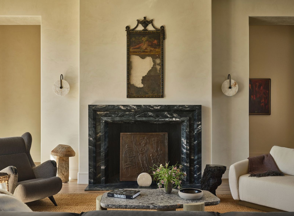 Cozy living room with marble fireplace, artwork, and modern furniture.