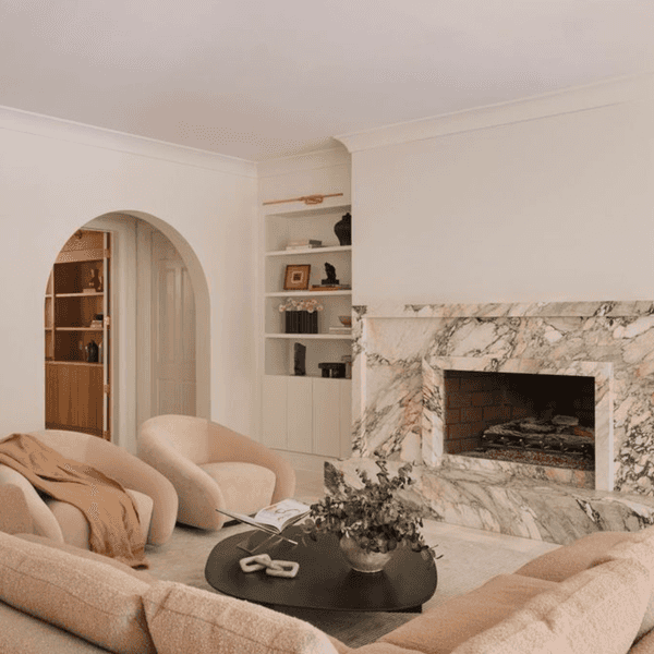 Cozy living room with marble fireplace, soft seating, and modern decor.