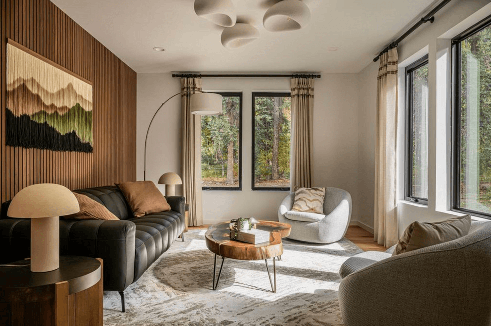 Cozy living room with modern furniture, large windows, and nature-inspired decor.