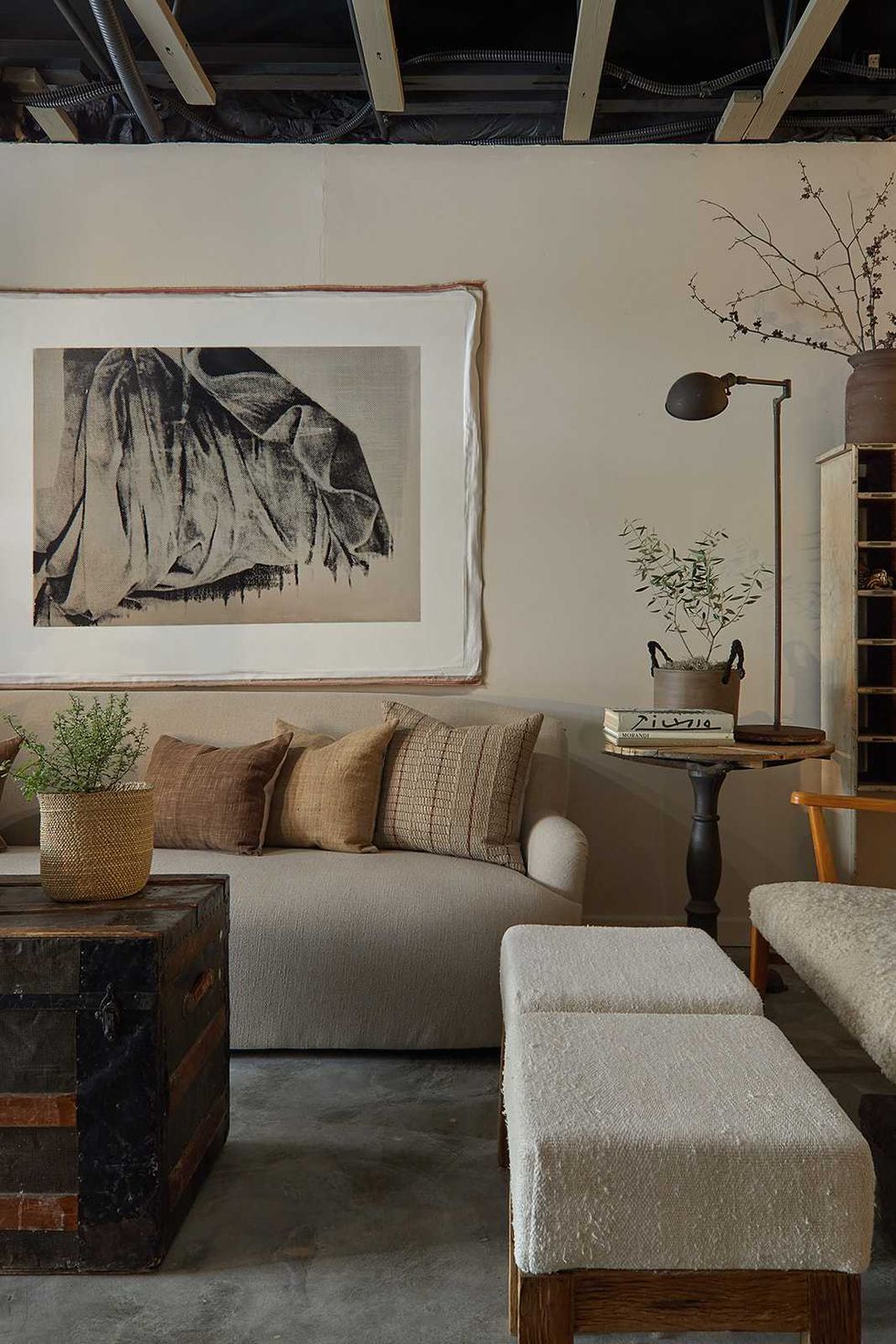 Cozy living room with neutral sofa, art piece, and rustic decor elements.