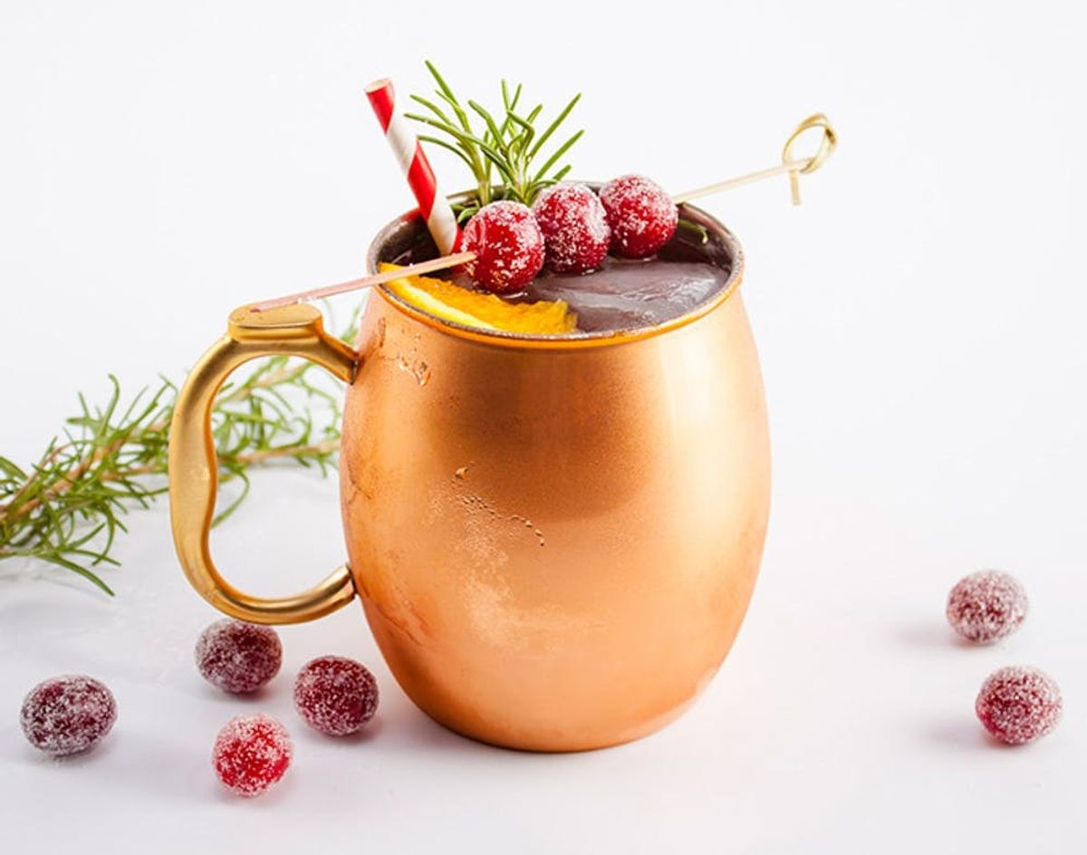 Cranberry Cocktail Recipes features a mule in a copper mug with frozen cranberries for your next holiday gathering.