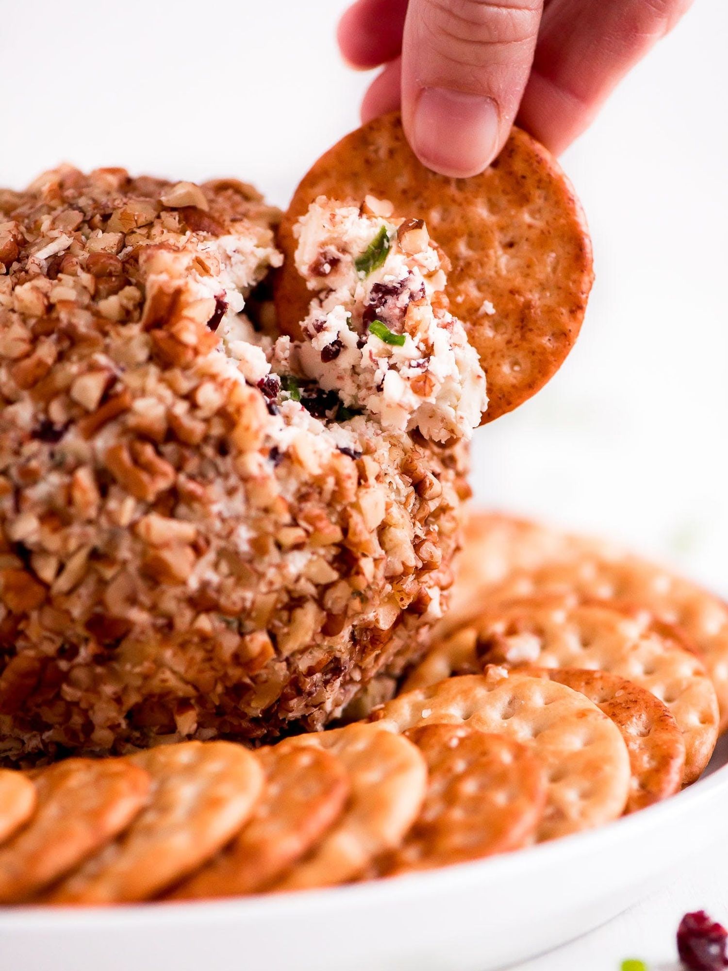 Cranberry Pecan Cheese Ball on a plate with some crackers
