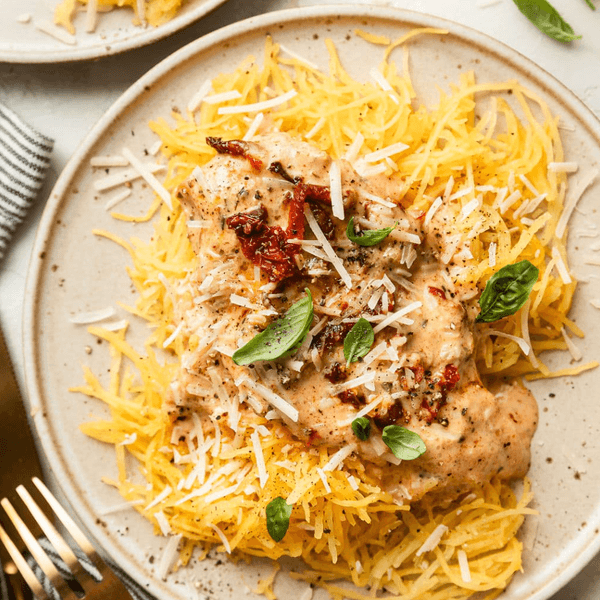 Creamy chicken on spaghetti squash, topped with cheese and basil.