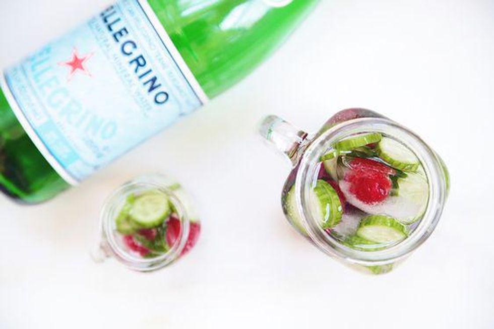 cucumber and raspberry water beside a bottle of sanpelligrino