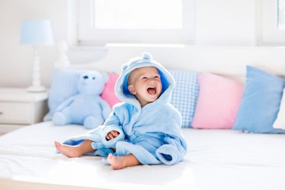 Cute baby in bathrobe or towel after bath