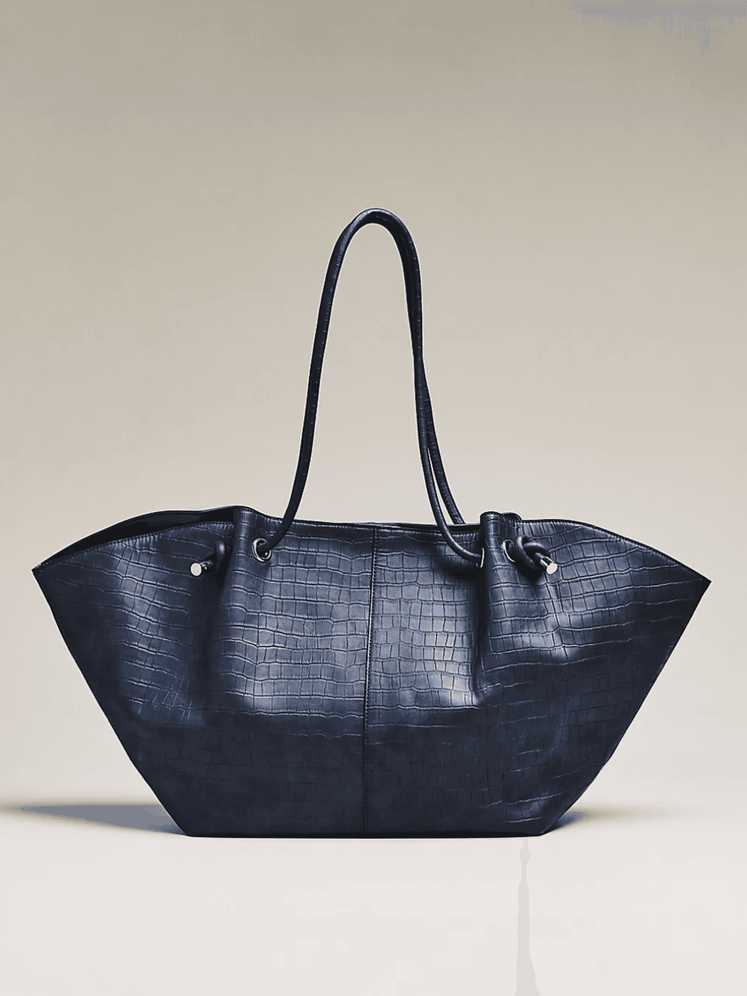Dark blue textured tote bag with long handles on a light background.
