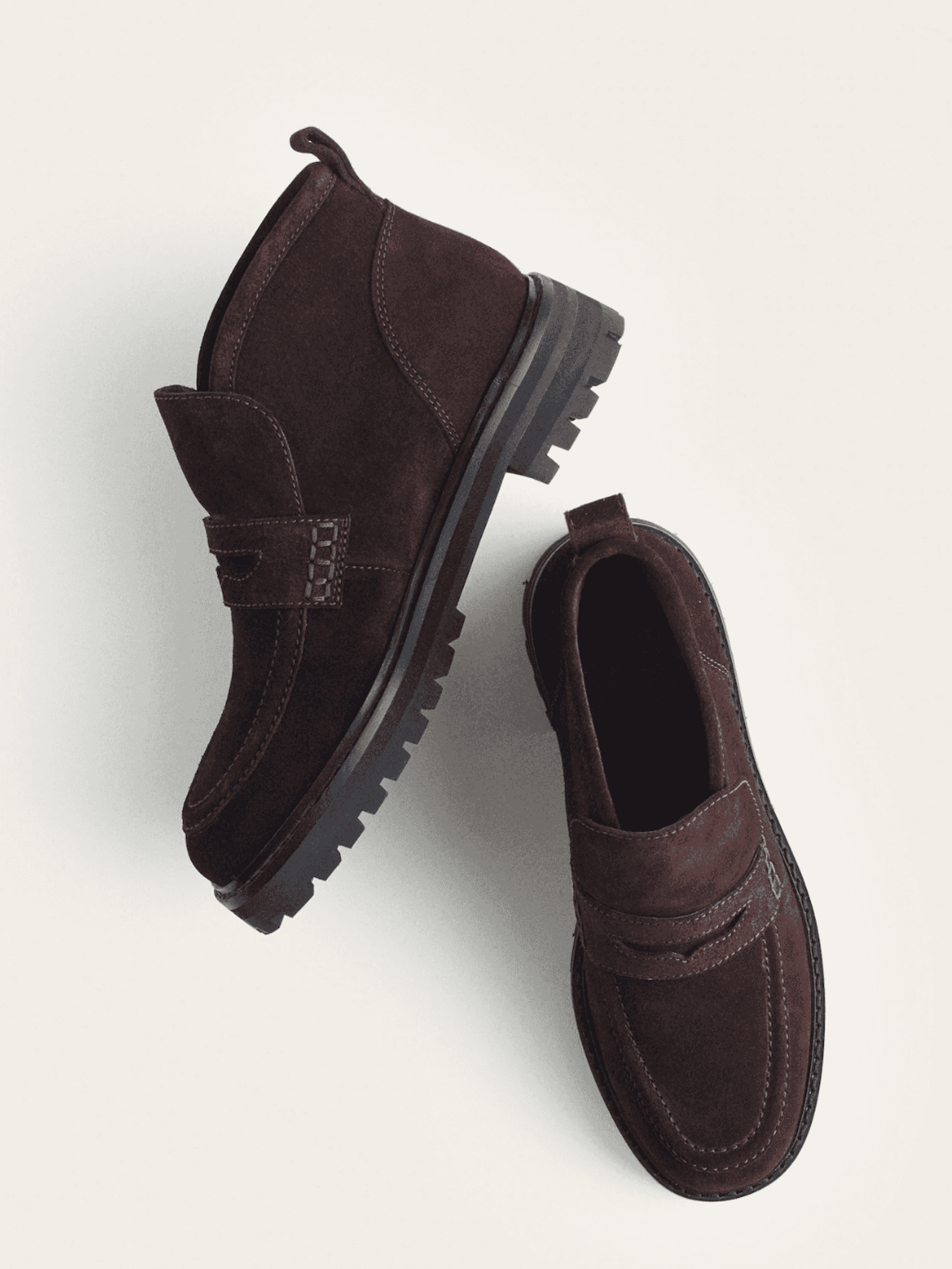 Dark brown suede loafers with rugged soles on a light background.