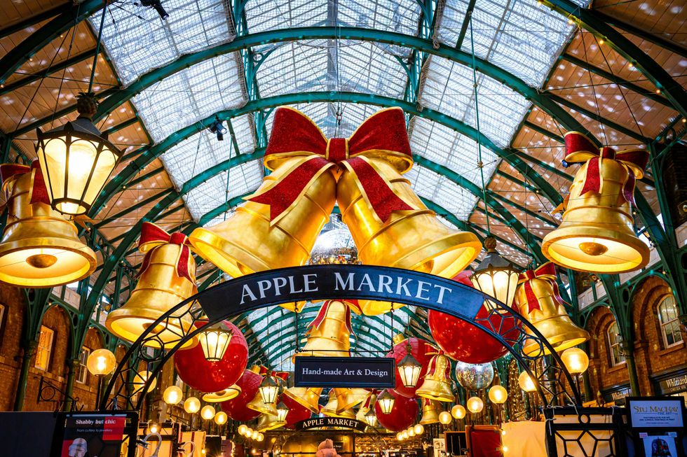 Decorative bells and ornaments hang in London's Apple Market under a glass roof.
