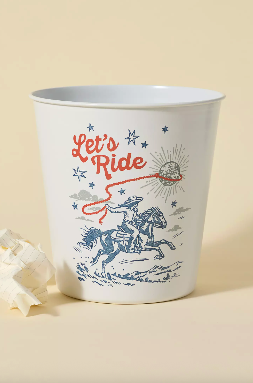 Decorative bin with cowboy lassoing a disco ball, text: "Let's Ride." Crumpled paper nearby.