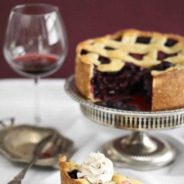 deep dish berry pie tart with whipped cream on a white plate
