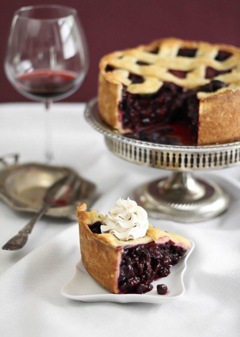 deep dish berry pie tart with whipped cream on a white plate