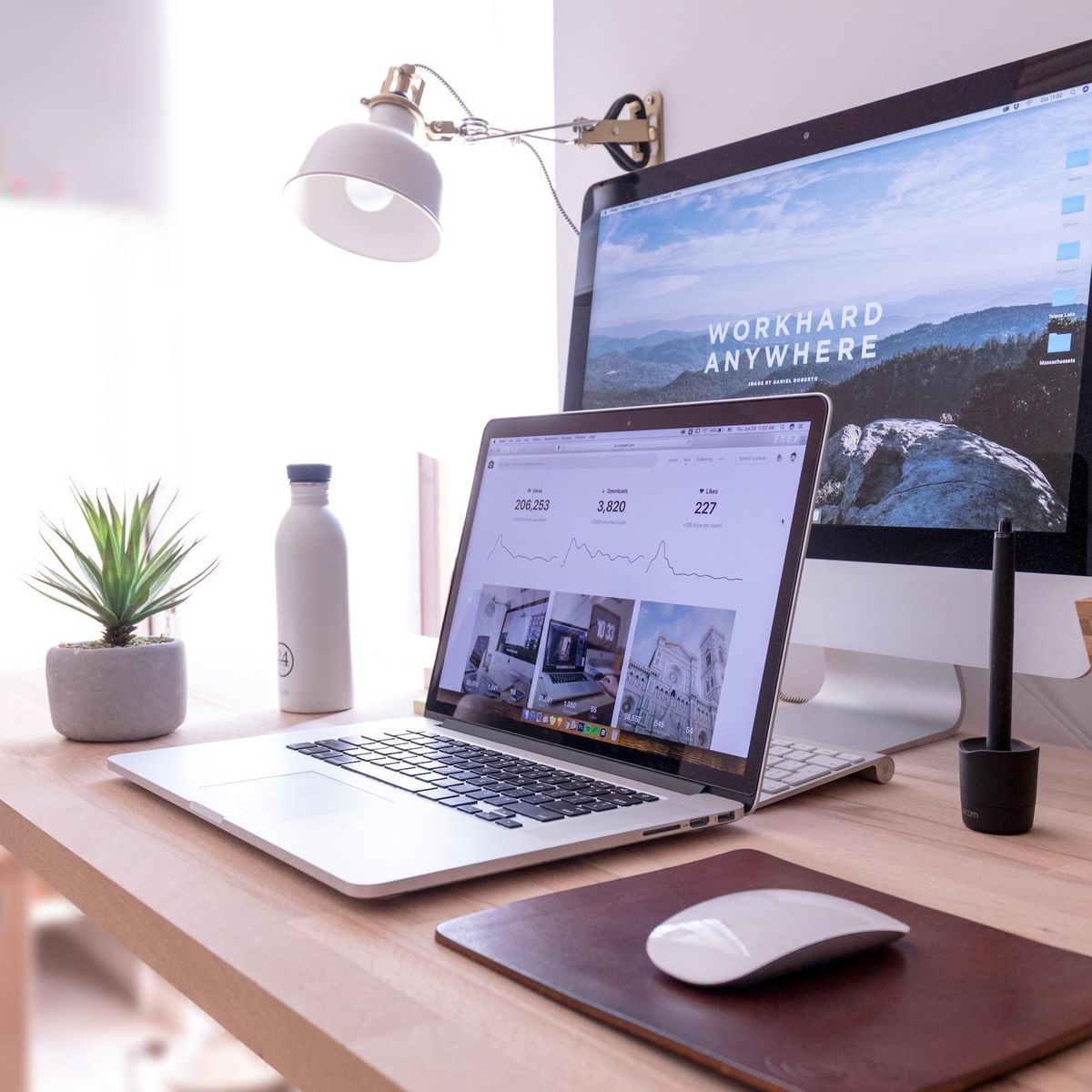 desk setup with laptop and plants Hustle Culture