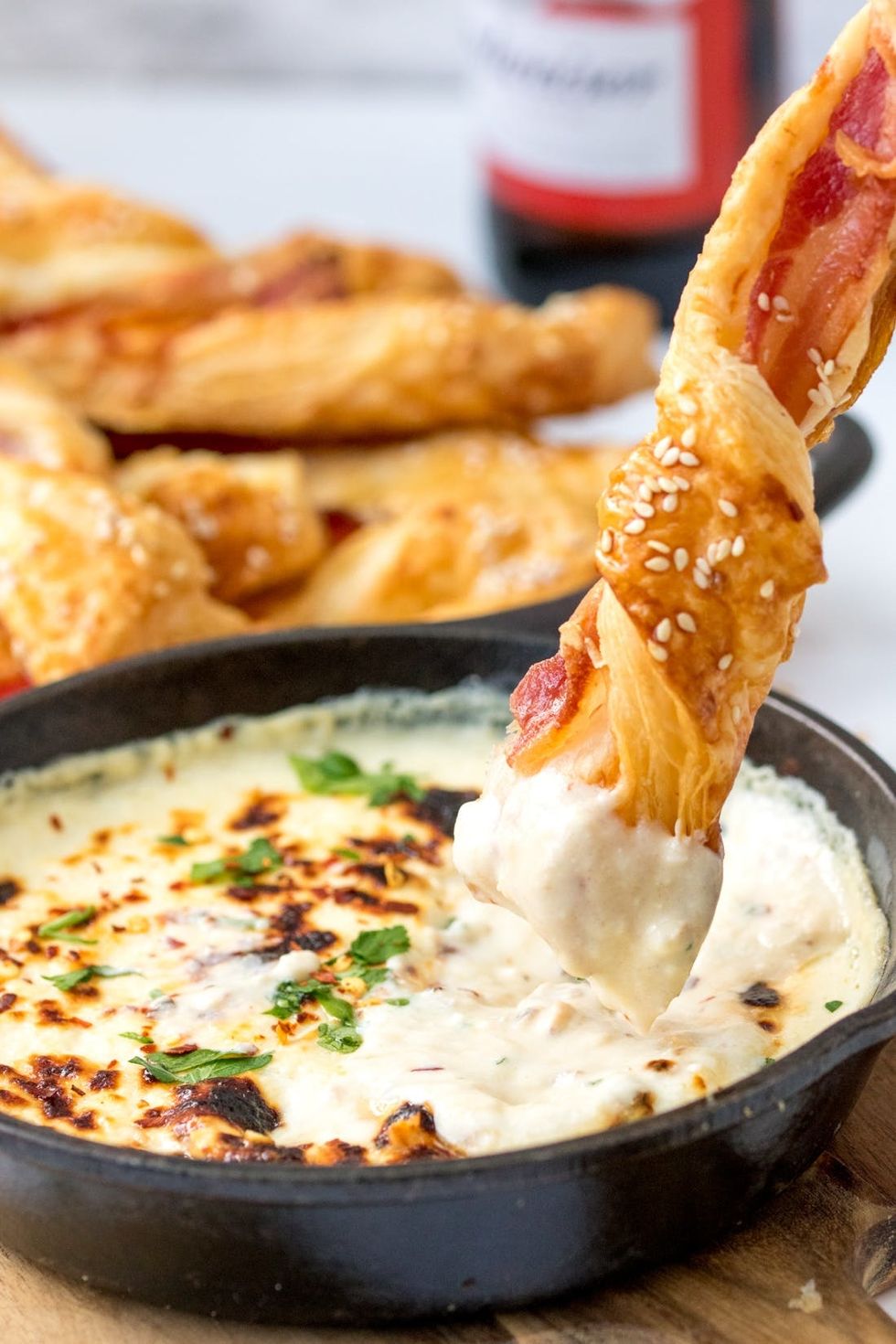 dipping a bacon pastry twist in the beer cheese dip