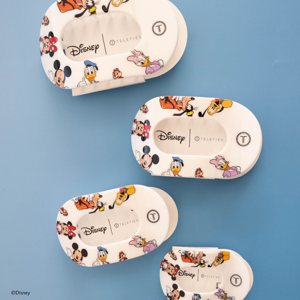 Disney-themed hair tie boxes on a blue background.