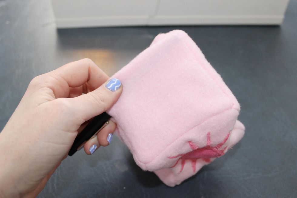 DIY Taylor Swift Fuzzy Dice using a pen to stretch out the cube corners