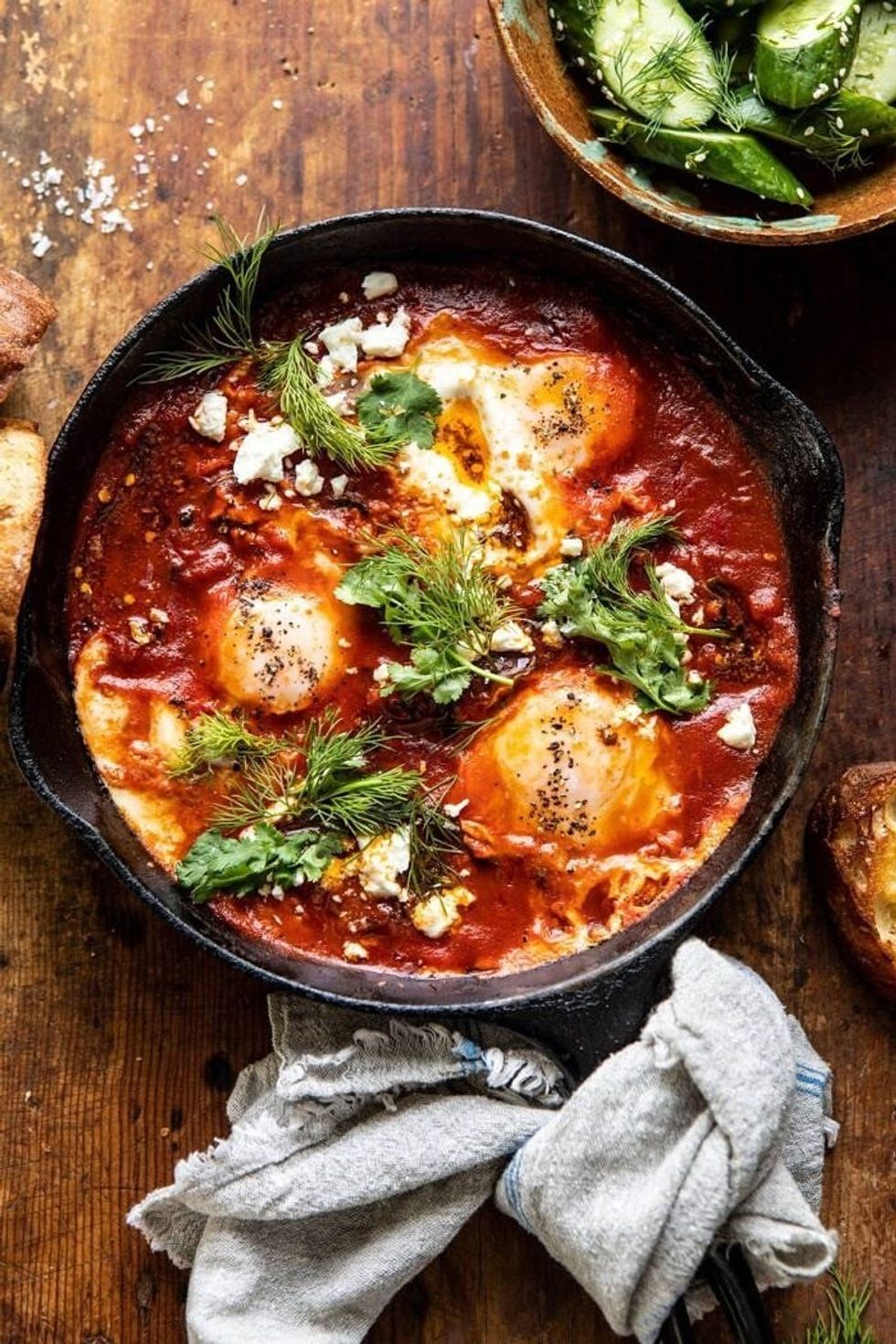 Eggs in purgatory sit on a wooden table, next to a tied piece of cloth.