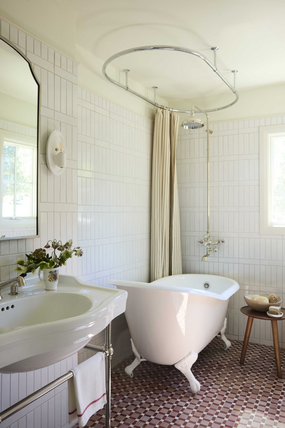 Elegant bathroom with a clawfoot tub, pedestal sink, and patterned floor tiles.