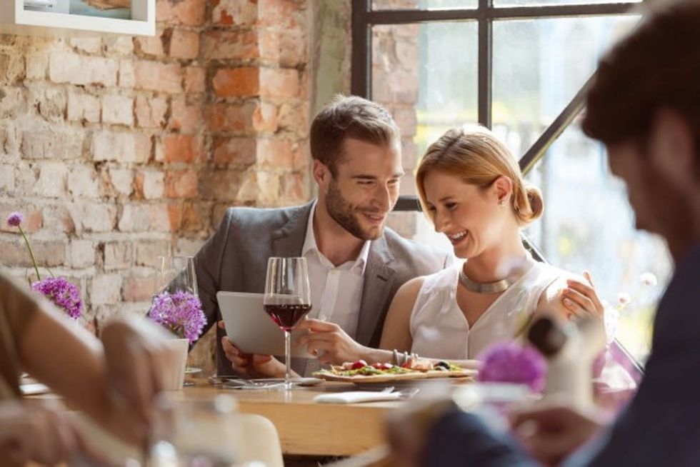 Elegant-couple-using-a-digital-tablet-in-the-restaurant-000078449605_Medium