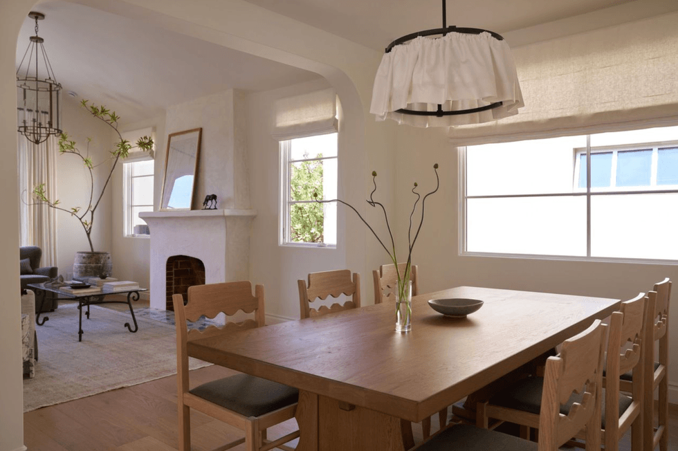 Elegant dining room and living area with wooden table and fireplace.