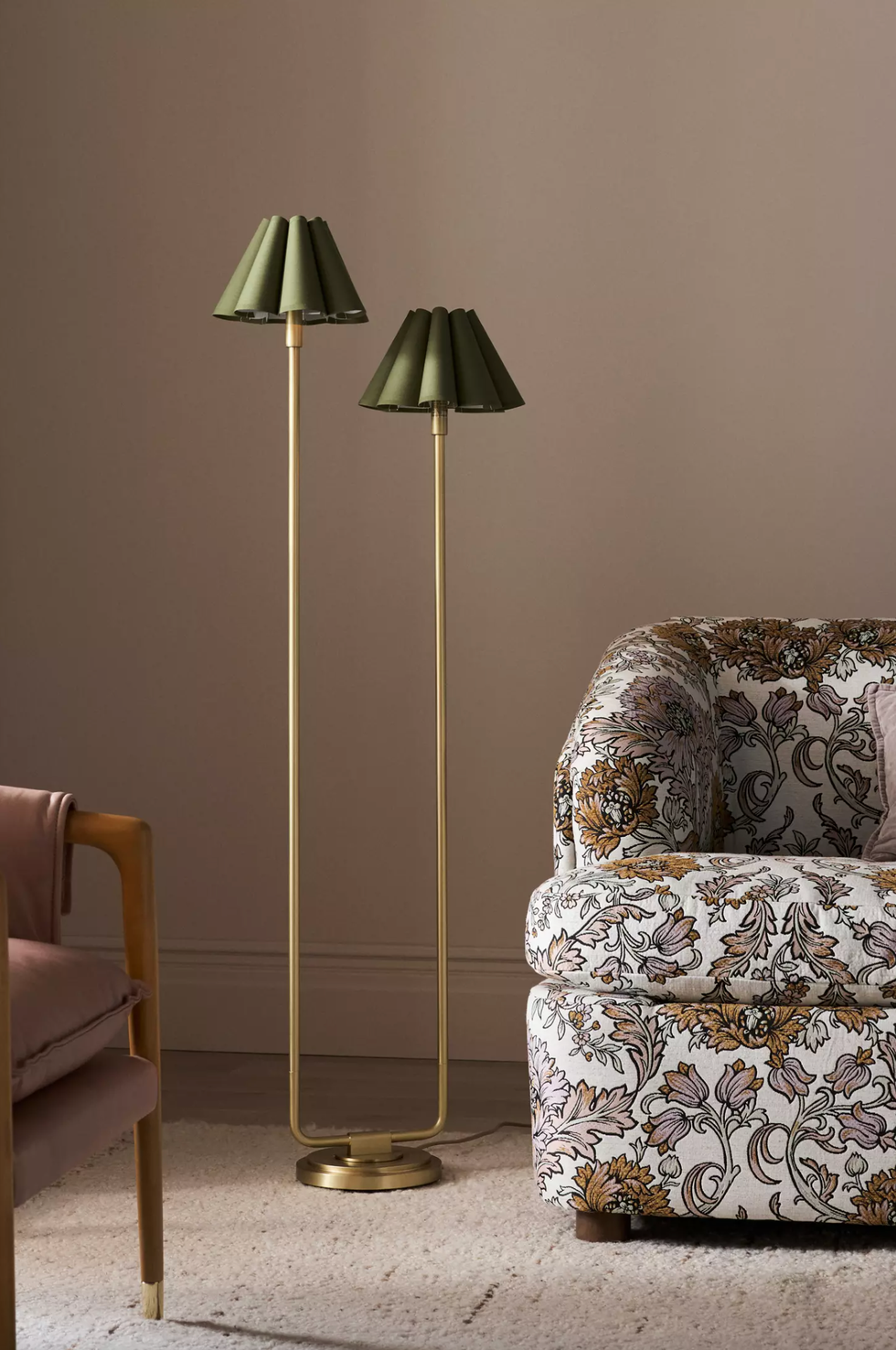 Elegant floor lamp and floral sofa in cozy living room corner.