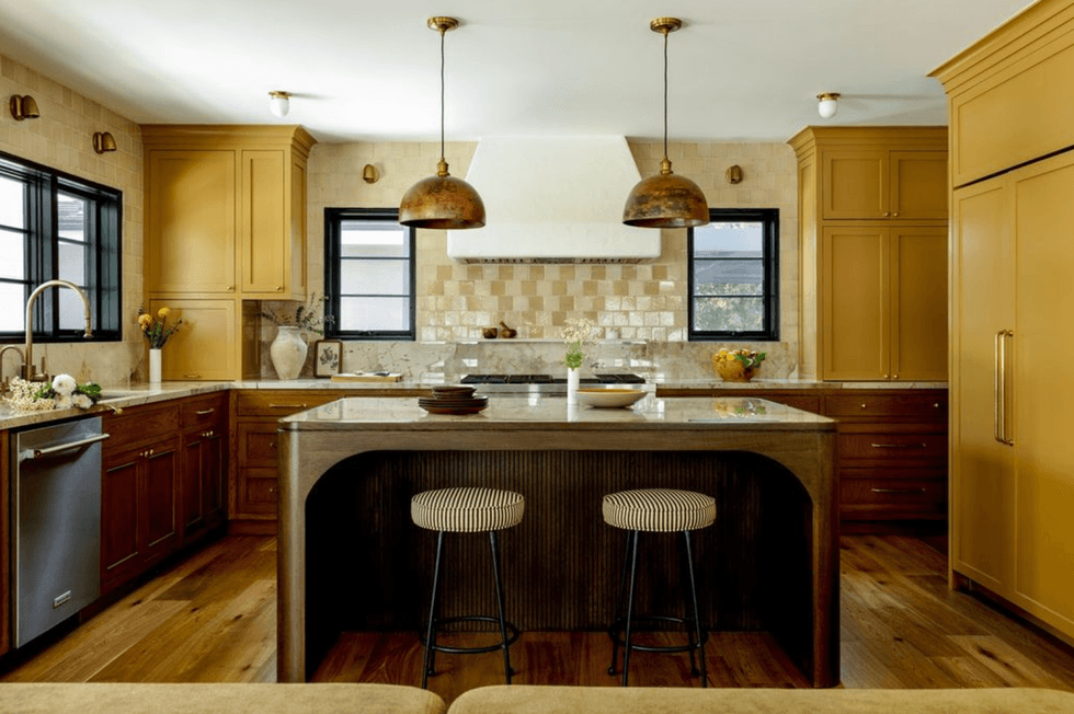 Elegant kitchen with warm wood tones, center island, and pendant lights.