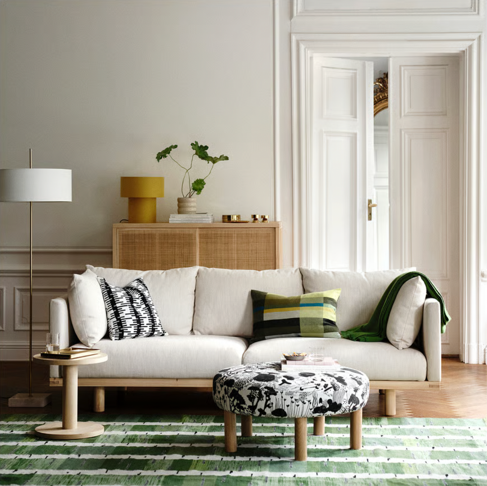 Elegant living room with a white sofa, colorful cushions, and a patterned rug.