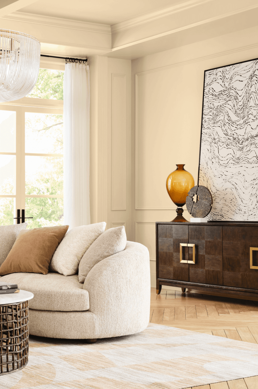 Elegant living room with beige sofa, wooden sideboard, and abstract wall art.