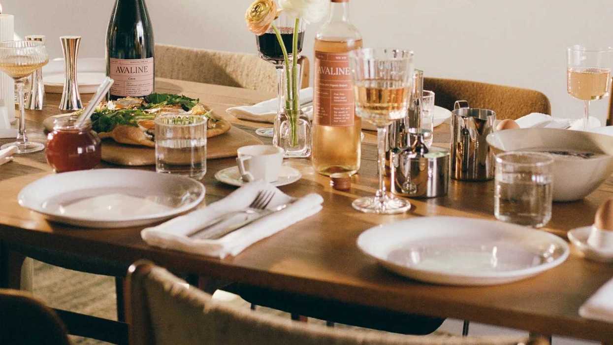 Elegant table setting with wine, pizza, flowers, and glassware.