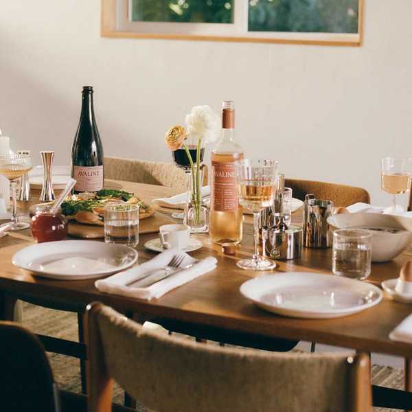 Elegant table setting with wine, pizza, flowers, and glassware.