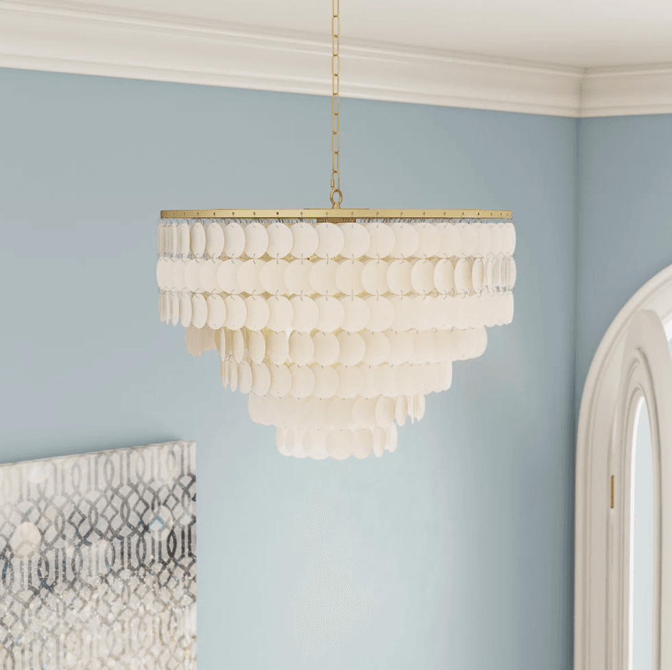 Elegant tiered chandelier with round pendants, in a soft blue room.