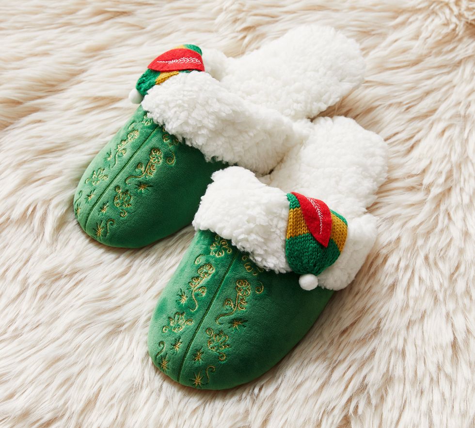 Elf slippers are on a white carpet.