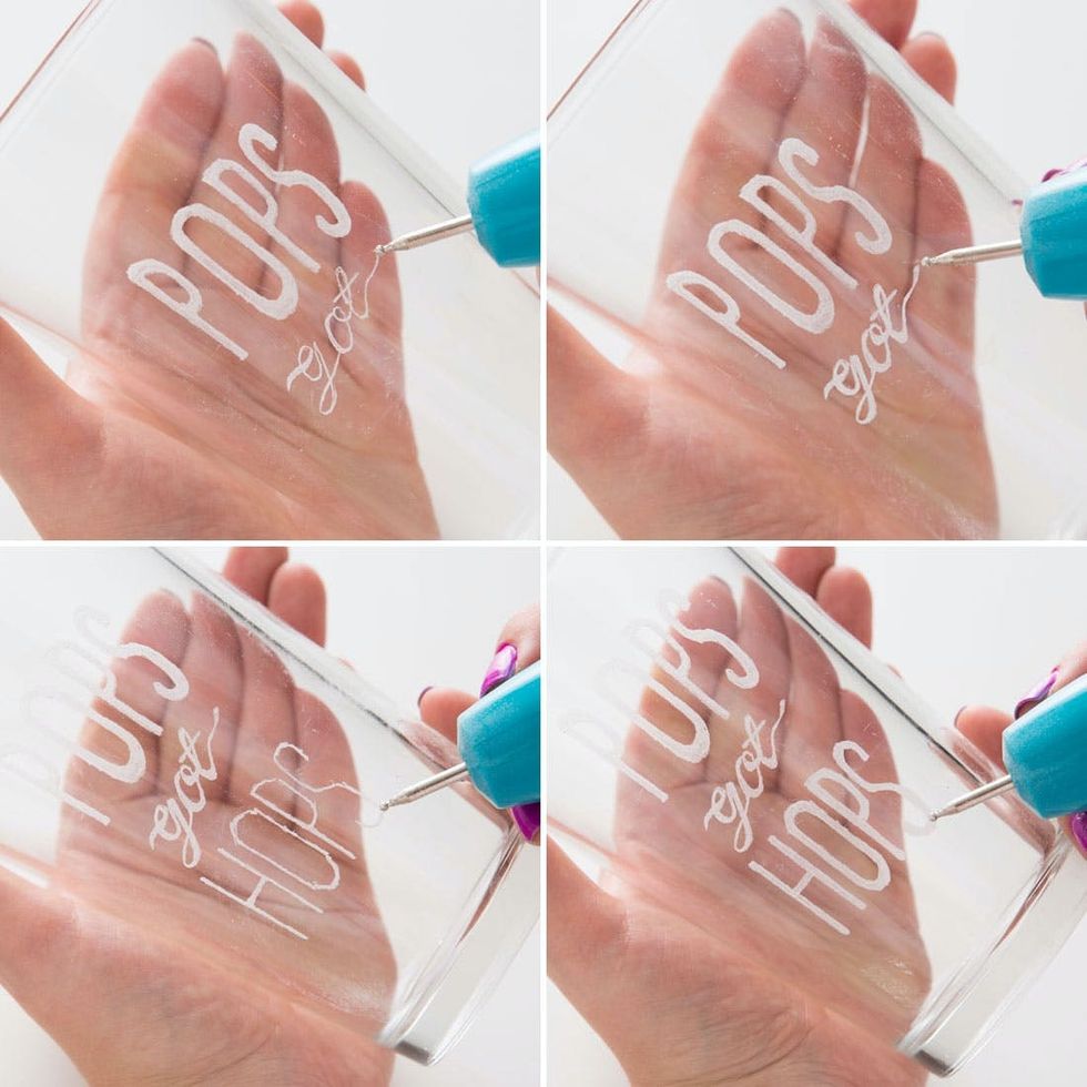 Engraving the phrase "Pops got hops" on a glass with a blue tool.