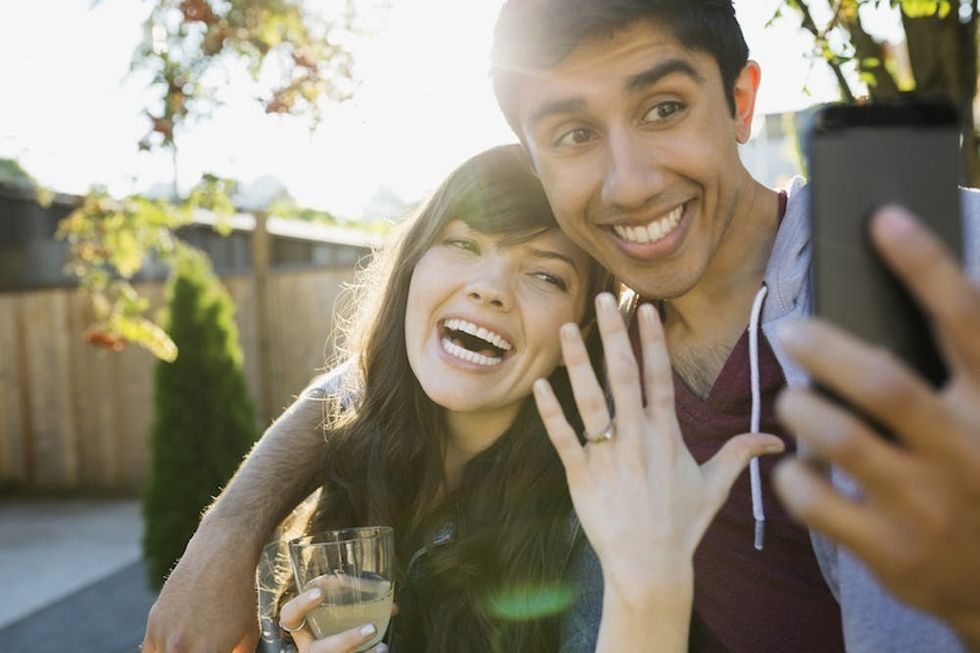 Enthusiastic couple taking selfie of engagement ring