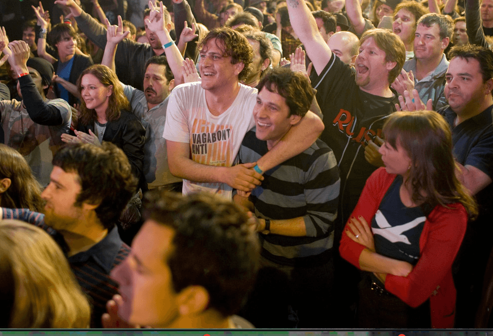 Enthusiastic crowd at a concert, cheering and enjoying the lively atmosphere.