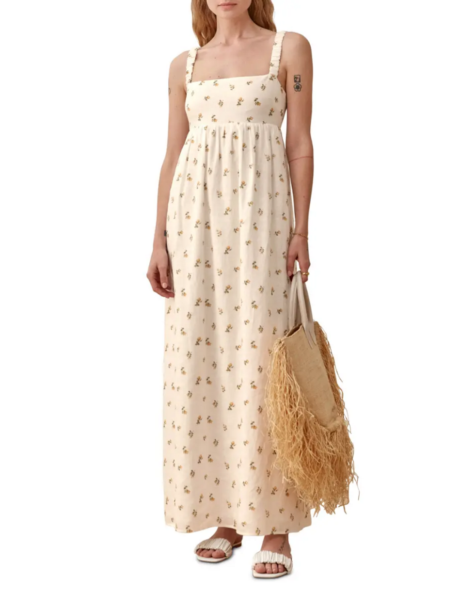 model wears cream sundress with flowers on it with cream sandals and bag