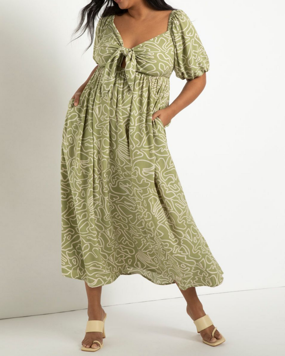model wearing green summer maxi dress with white design and strappy sandals