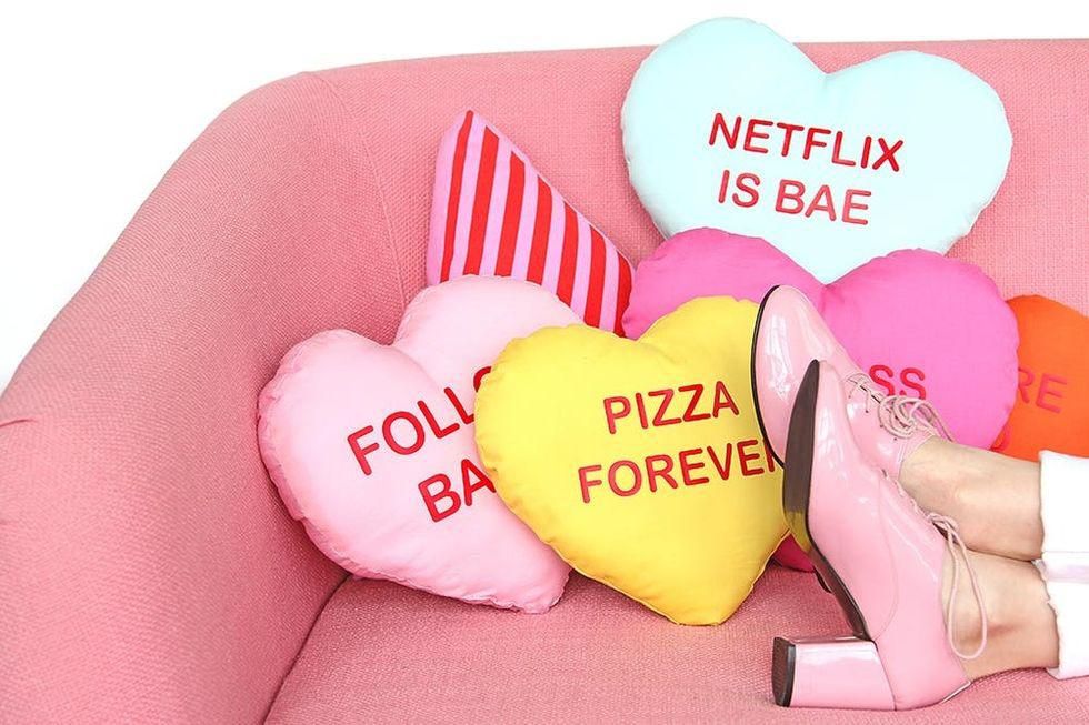 DIY Conversation Heart Pillows with red lettering and a model's pink heels
