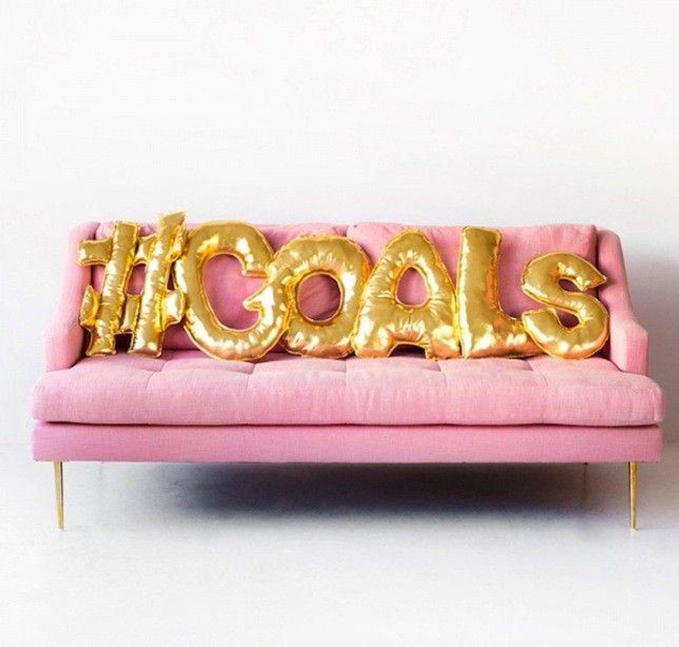 golden balloon letters on a pink couch