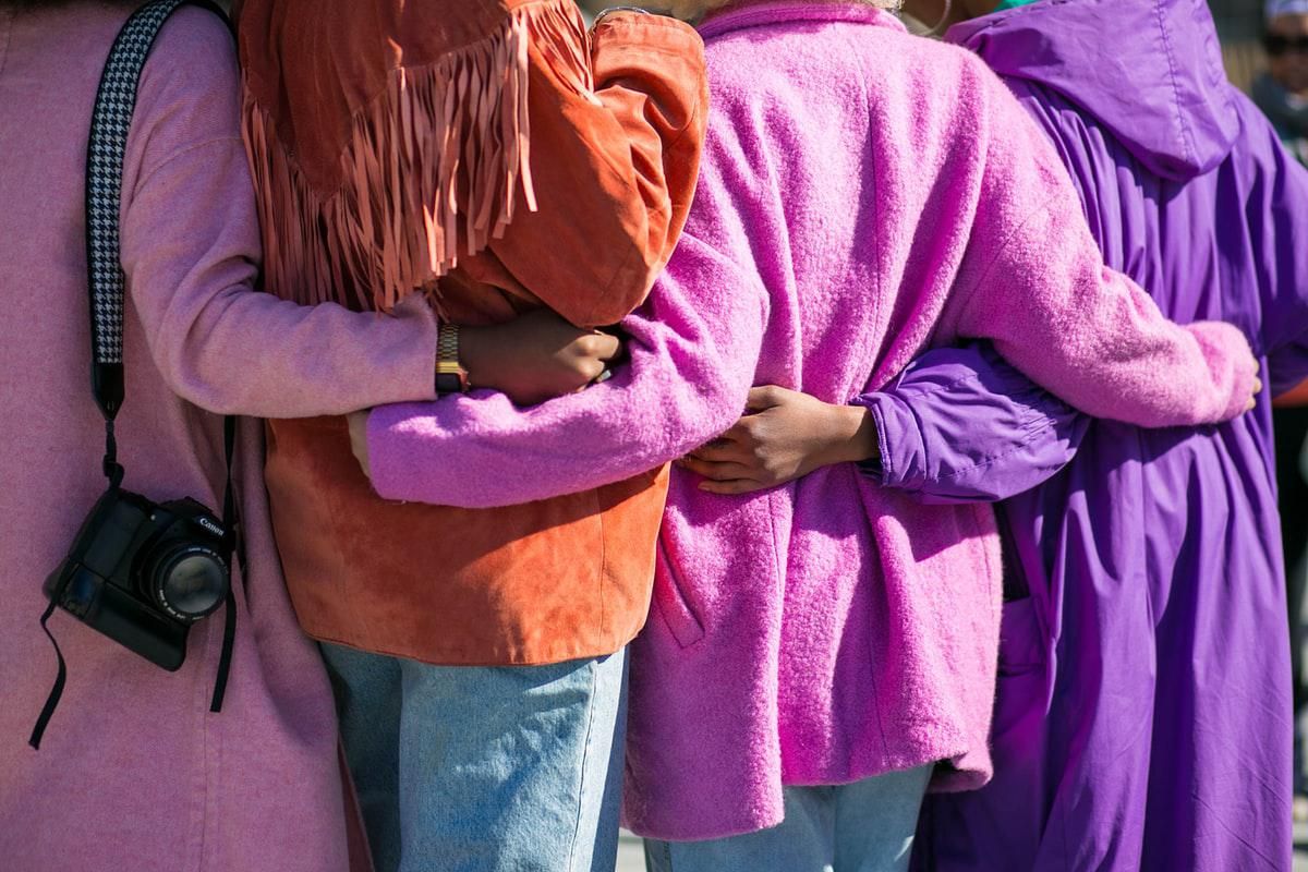 women in colorful coats standing together