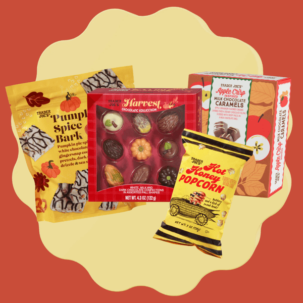 Fall-themed snacks assortment: popcorn, chocolates, bark, and caramels on a red background.