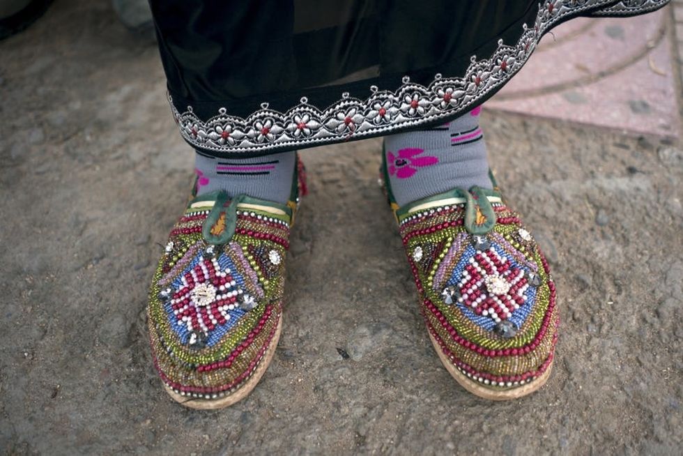 Fatima, a local woman shows off her home made slippers that she sells in Tafraout, a city nestled amongst Morocco's Anti-Atlas Mountains