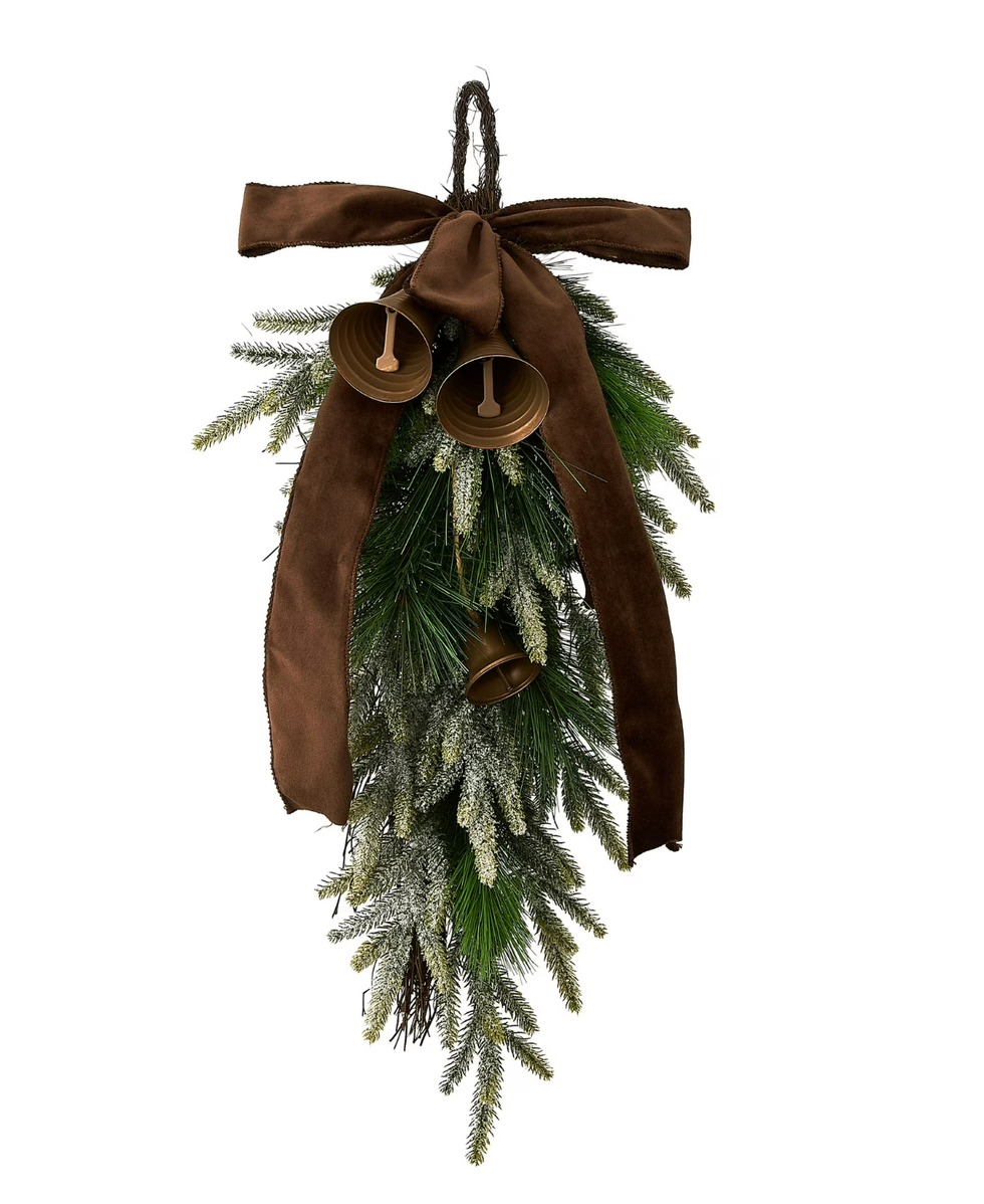 Festive hanging greenery with bells and a brown bow.