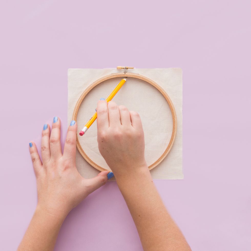 First, you\u2019ll want to trace the inside circumference of the embroidery hoop onto your linen fabric using pencil.