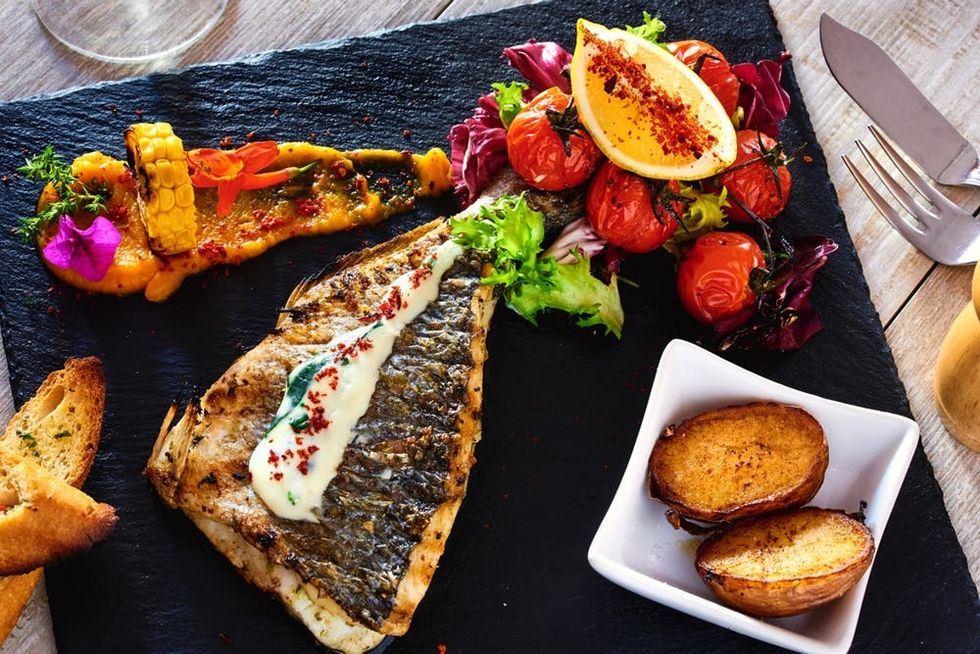 Fish served with vegetables and sauce