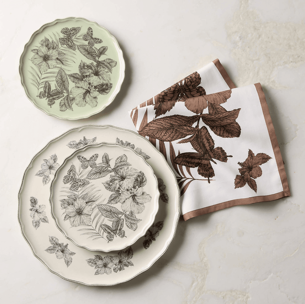 Floral-patterned plates with matching napkins on a marble surface.