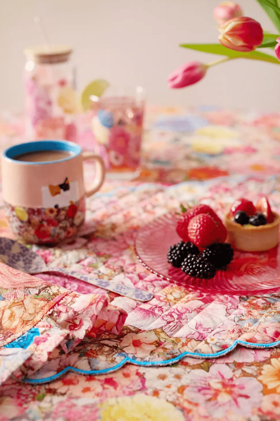 Floral table setting with coffee, berries, and tulips.